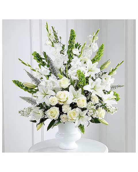 White lilies and roses arranged in a white vase