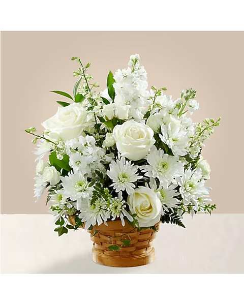 White roses and daisies arranged in a woven basket