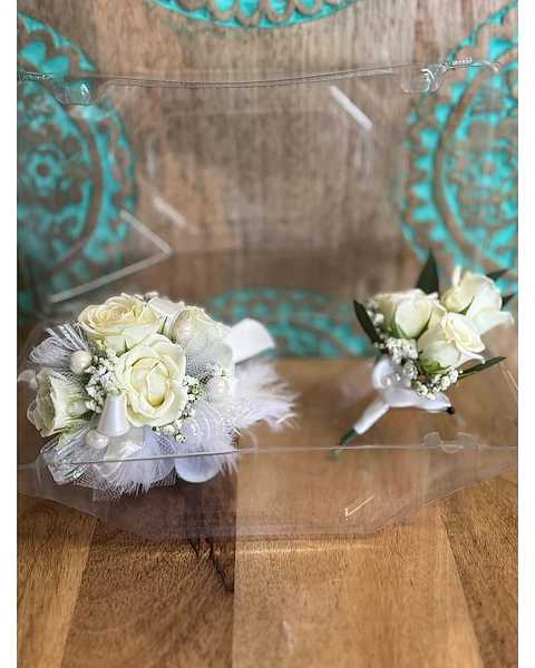 Two small white rose boutonnieres with feather accents