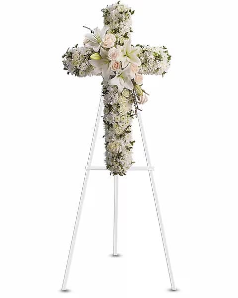 White floral cross arrangement on a standing easel