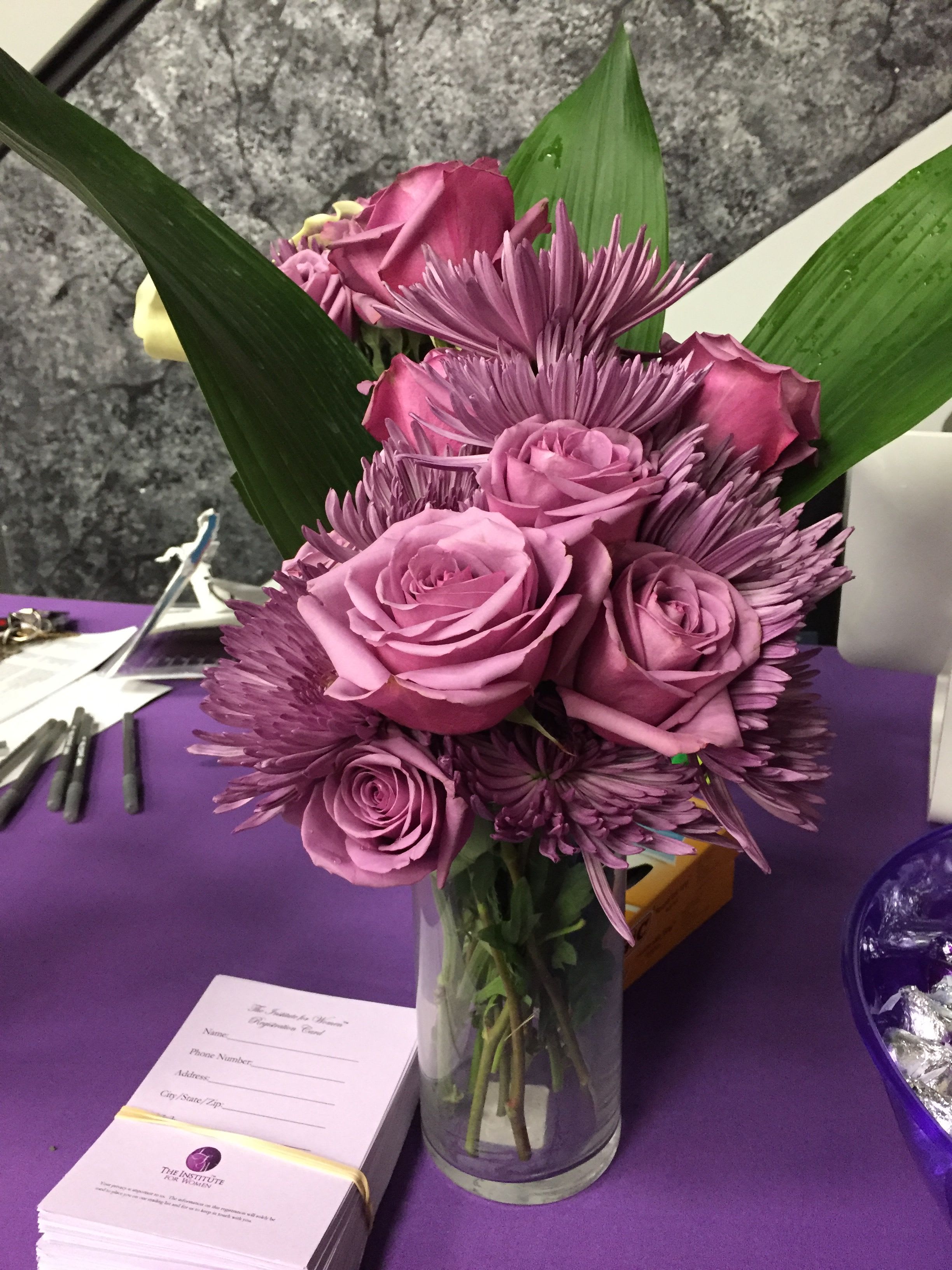 Purple Passion - Lavender and pink roses with purple chrysanthemums and green foliage in a clear glass vase-elegant, layered bouquet perfect for romantic gifts, celebrations, or polished event displays.
