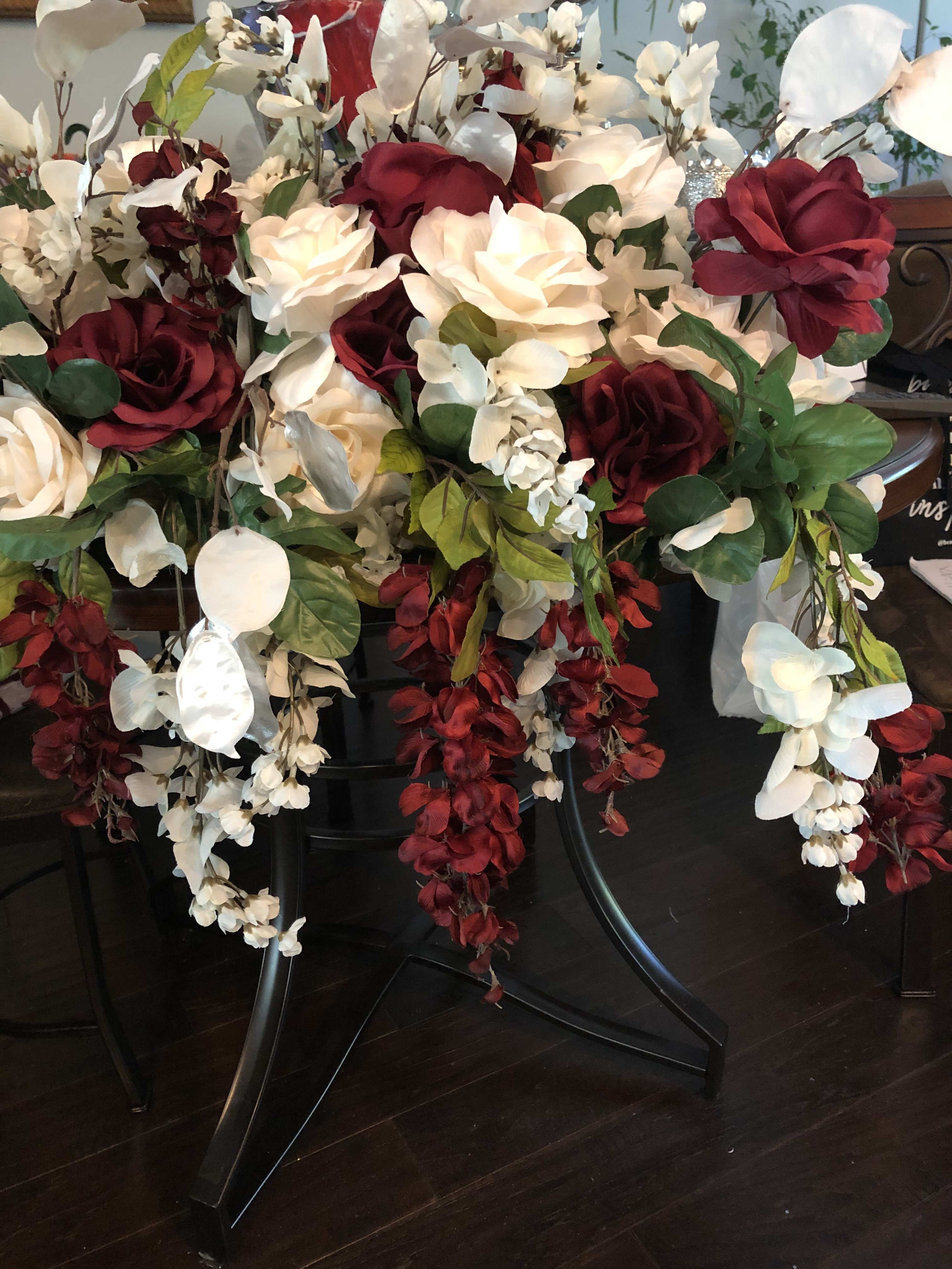 Large arrangement of red and white roses with cascading white orchids