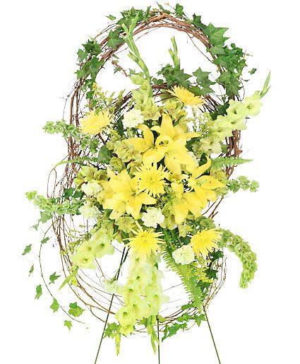 Soulful Hallelujah - Celebrate the life of a lost loved one with an enchanting spray that will personify their spirit and bring calming beauty to those who are mourning during this time of loss. The Soulful Halleluja standing spray brings beauty to life with vibrant yellow lilies and spider mums, accents of pale green carnations, and a grapevine wreath deconstructed to represent the infinite love that continues on within you.  Includes Easel, Large Grapevine Wreath (Deconstructed), Large Wet Floral Foam Cage, Foliage: Ivy, Sword Fern, Green Gladiolus, Bells Of Ireland, Yellow Spider Mums, Yellowgreen Alstroemeria, Green Carnations, Solidago , Yellow Asiatic Lilies.