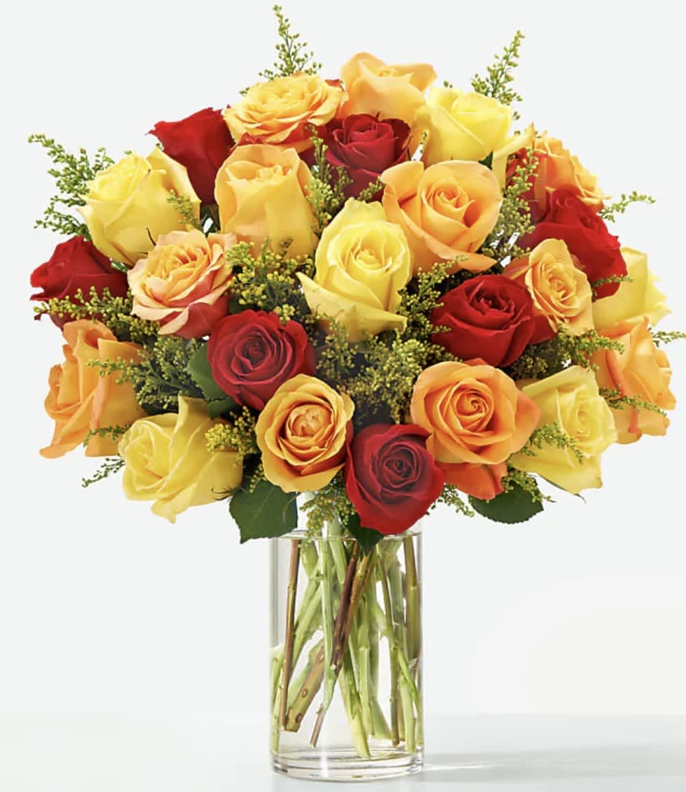 Bouquet of red, yellow, and orange roses in a clear glass vase