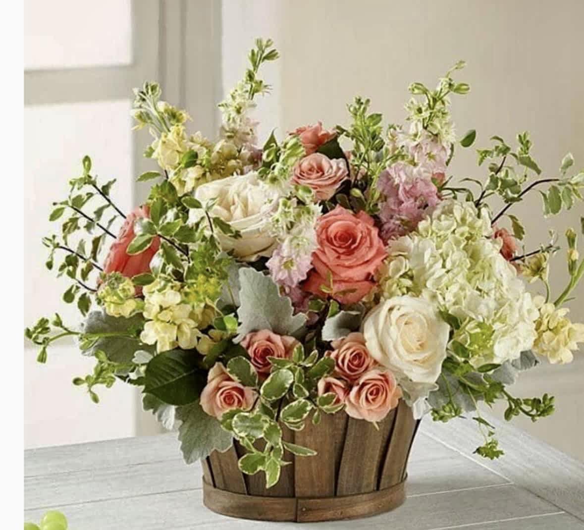 Mixed bouquet of pink and white flowers in a wooden basket