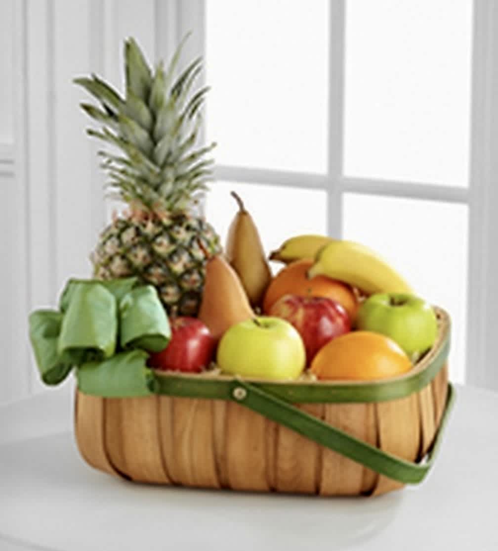 Fruit basket with pineapple, bananas, pears, apples, and oranges in a woven basket
