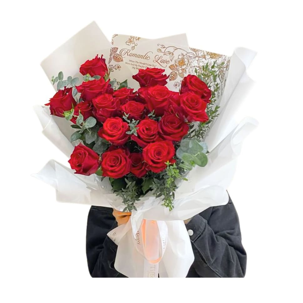 Bouquet of red roses wrapped in white paper with a ribbon