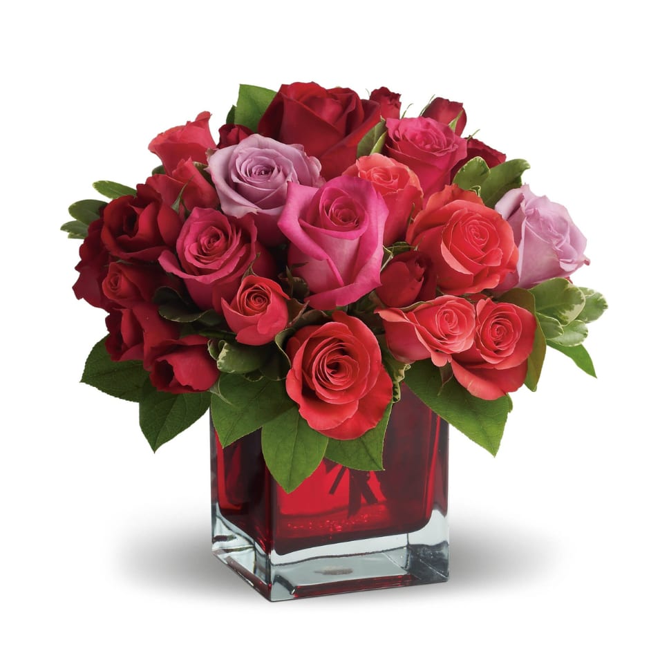 Bouquet of red, pink, and lavender roses in a red glass vase