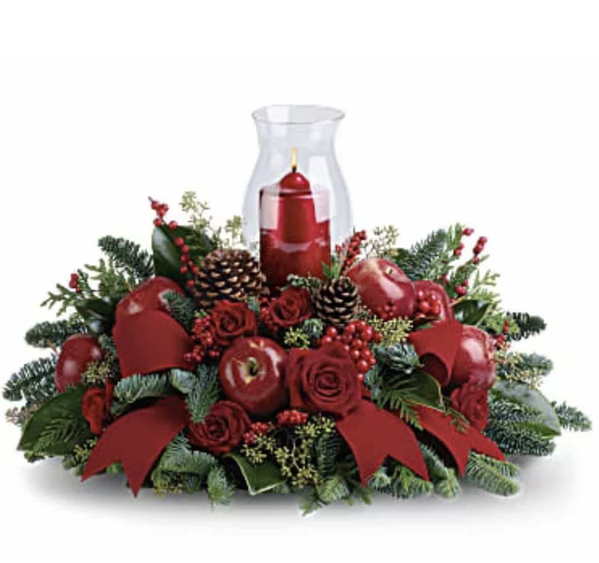 Red candle in a glass hurricane surrounded by roses and pinecones