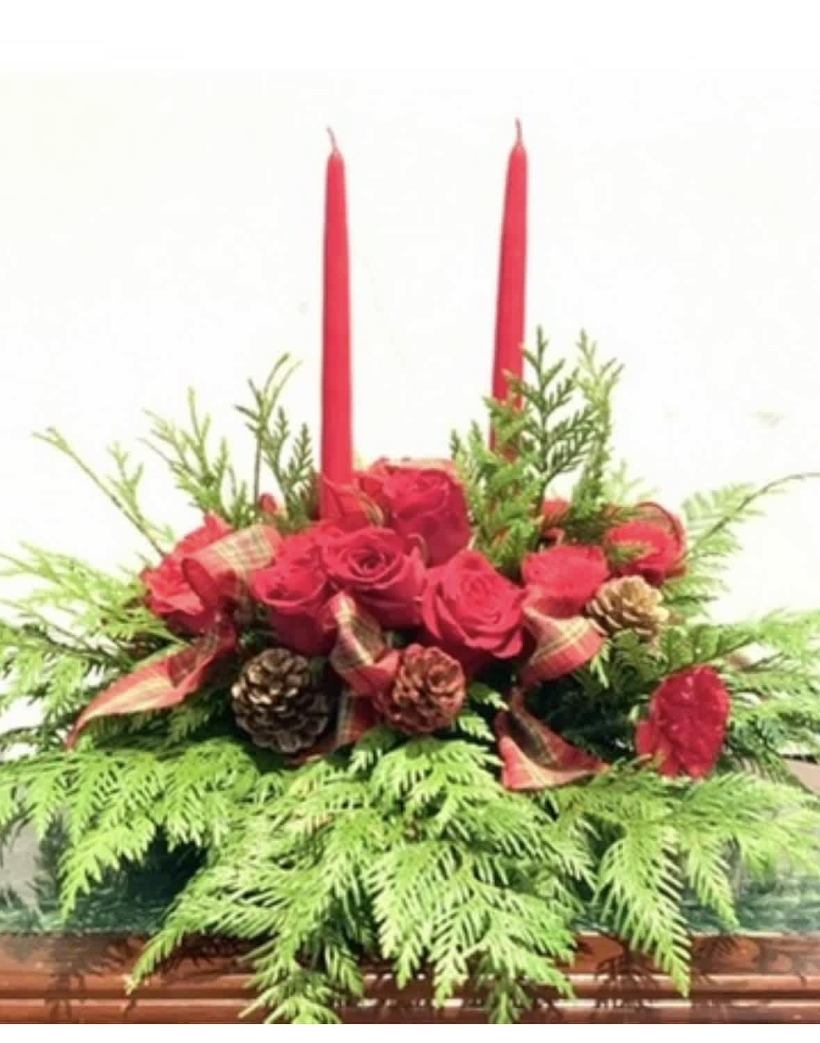Red rose centerpiece with two tall red candles and pinecones