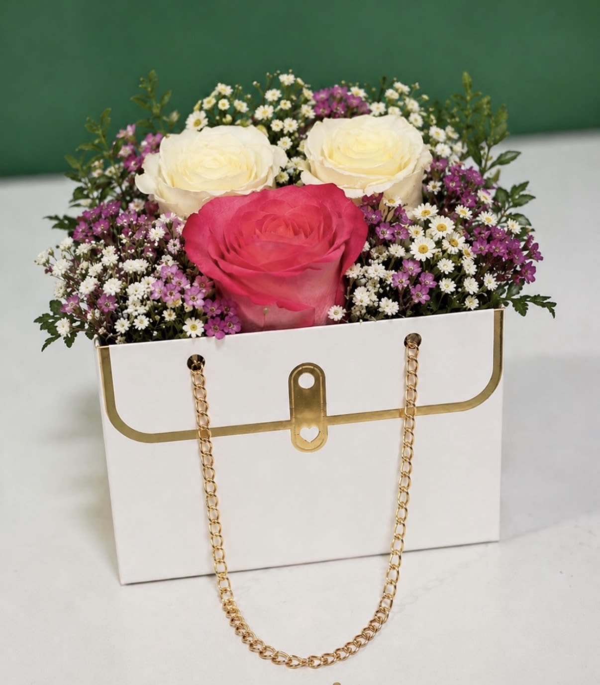 Petite Purse Bloom - Fresh seasonal blooms arranged in our elegant purse box. Perfect for birthdays, anniversaries, thank-you gifts, or just because. Available in White, Red, Pink, or Black. Flower colors may vary by season. 