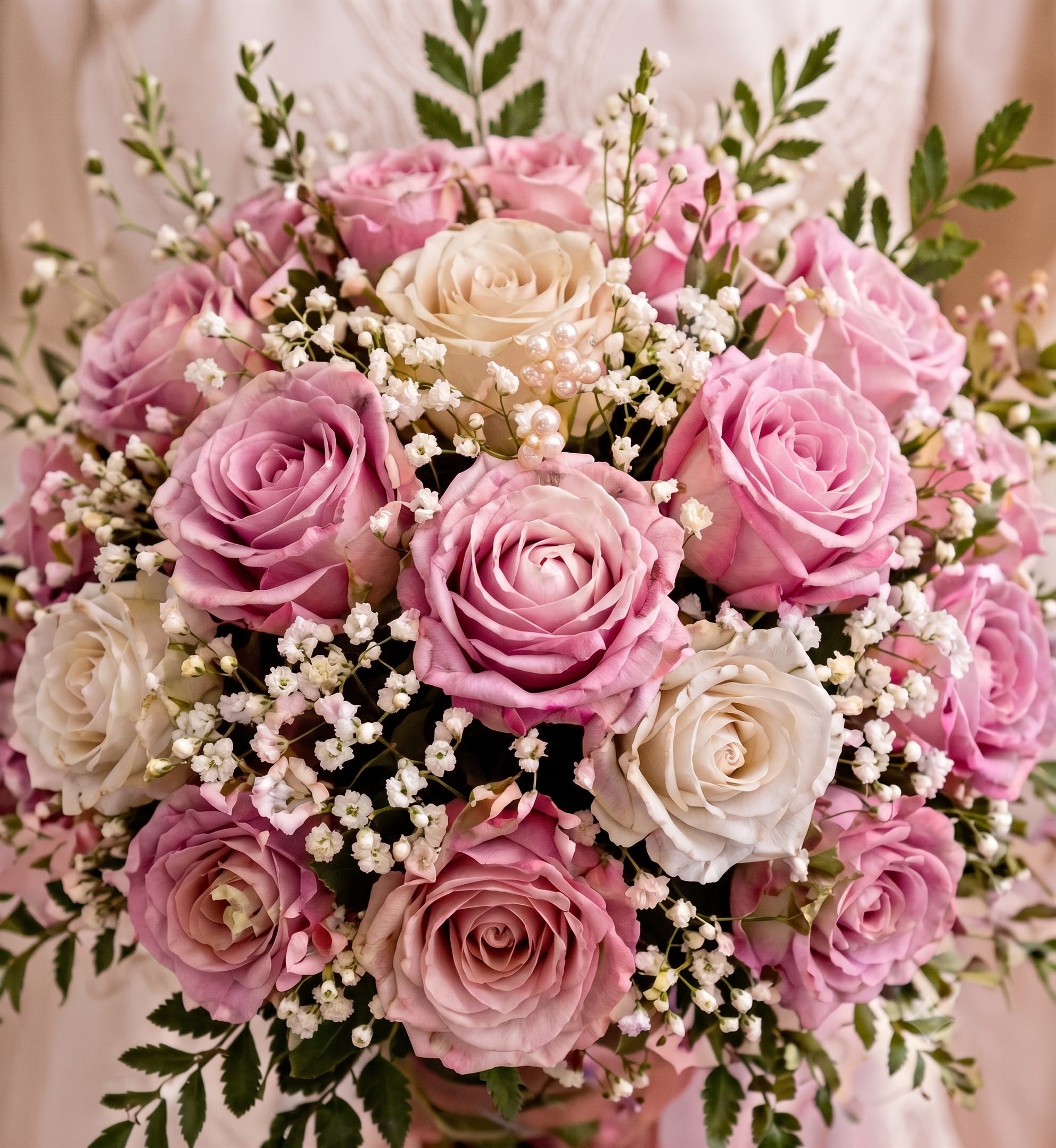 Pink Perfection Vase - A romantic vase bouquet featuring pink and ivory roses, delicate baby’s breath, seasonal accents, and fresh greenery. Flower varieties and shades may vary slightly based on availability.  
