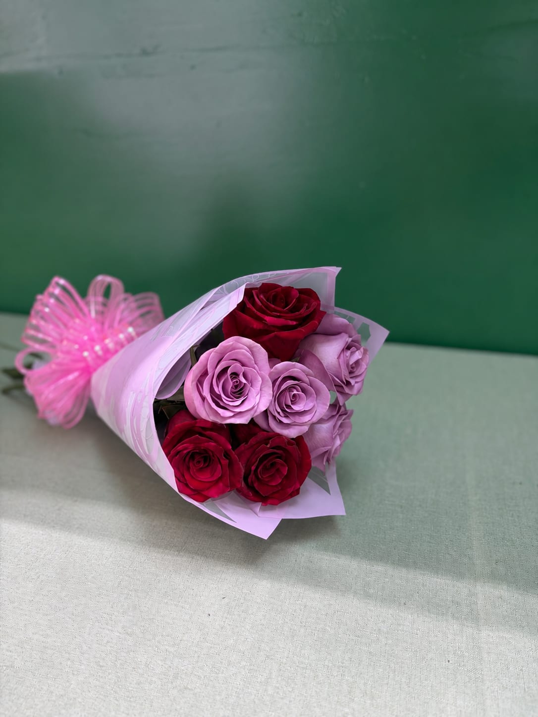 Bouquet of red and lavender roses wrapped in pink paper