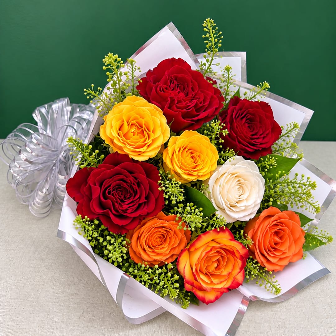 Bouquet of red, yellow, white, and orange roses wrapped in white paper