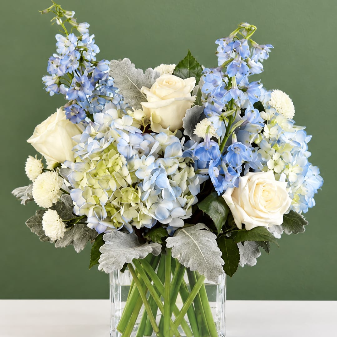 Blue and white flower arrangement in a clear glass vase