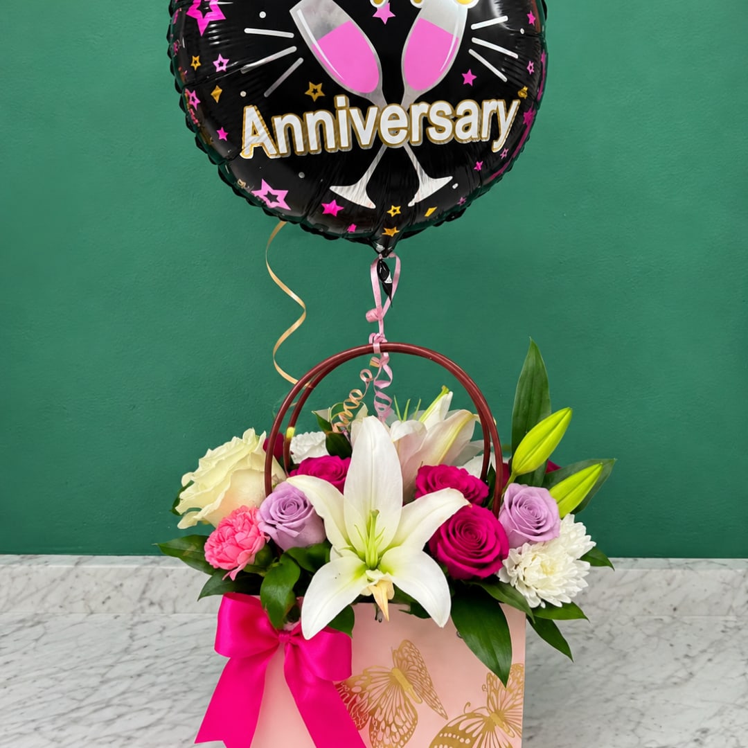 Flower arrangement in a pink gift box with an anniversary balloon