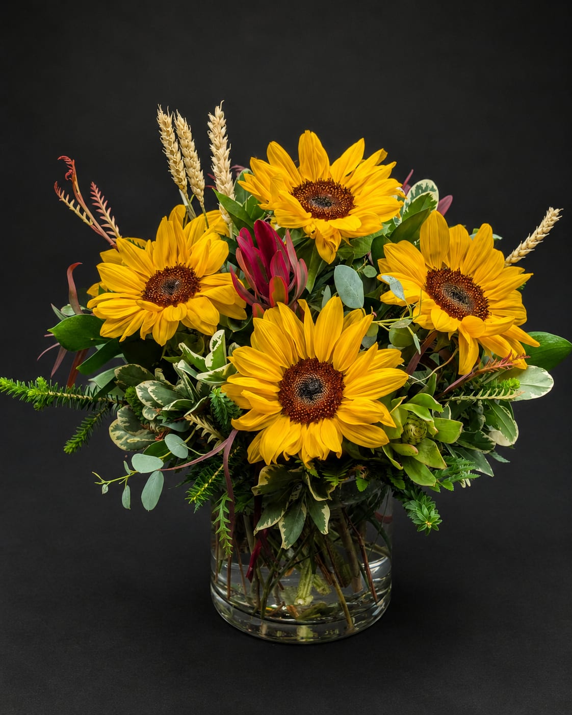Bouquet of yellow sunflowers in a clear glass vase