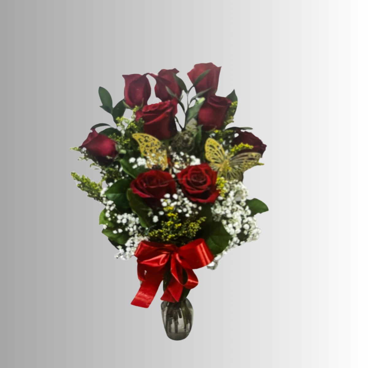 Bouquet of red roses with baby's breath in a glass vase and red ribbon
