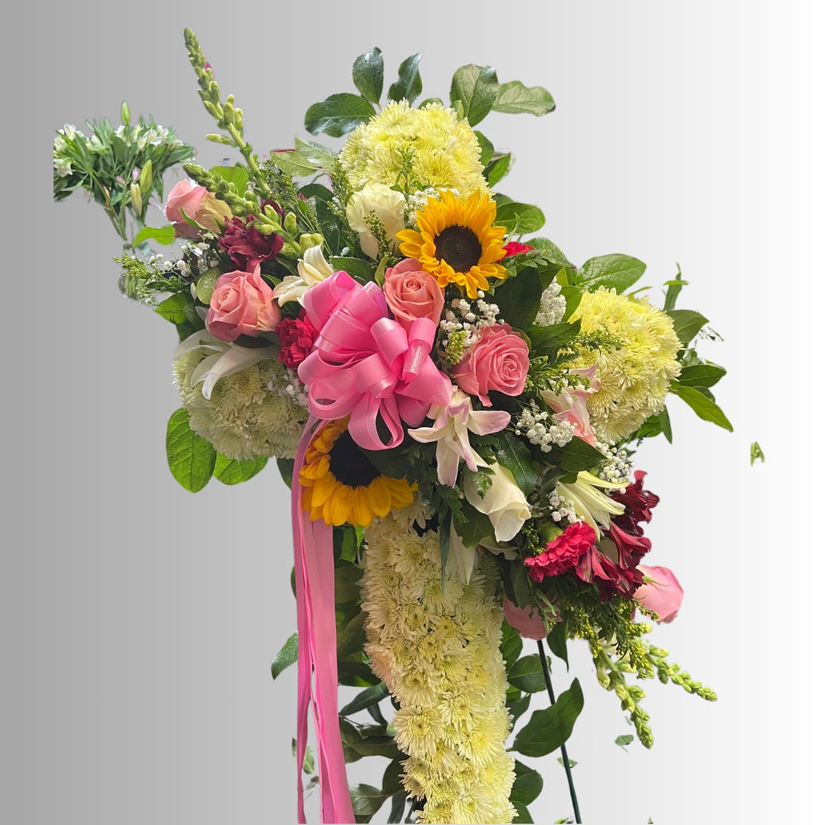 Large bouquet with pink roses, sunflowers, and yellow chrysanthemums tied with a pink ribbon