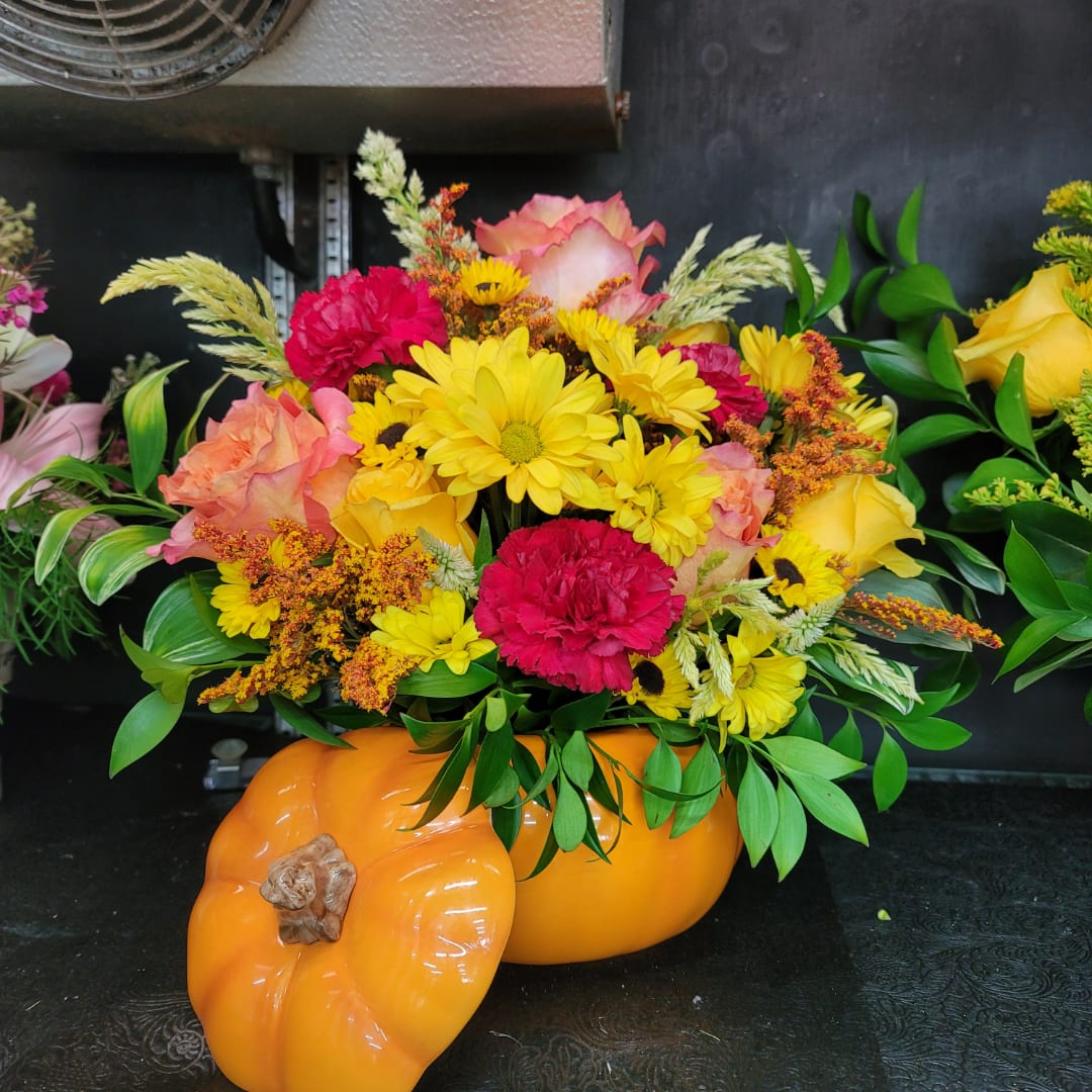 Bright mixed bouquet in an orange pumpkin-shaped container
