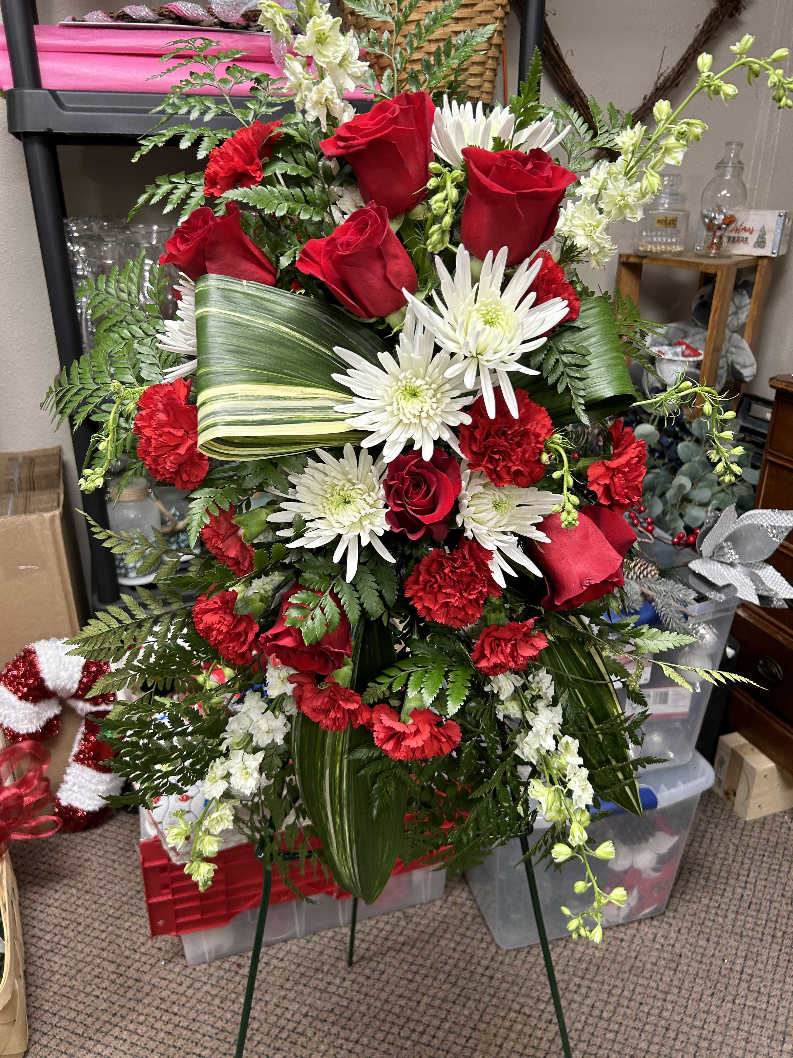 Red roses and white daisies arranged in a standing spray