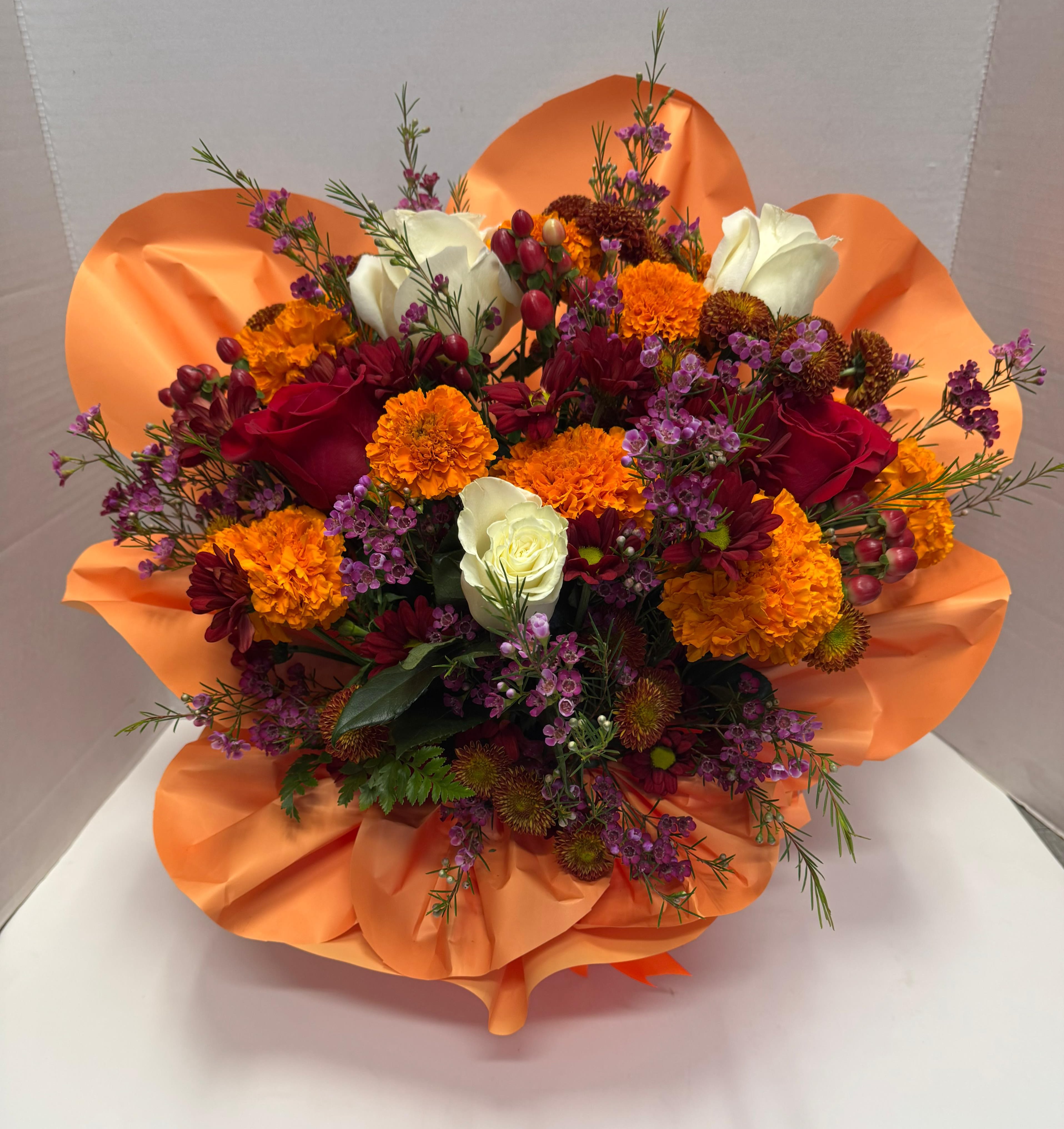 Marigolds Arrangement  - Let this beautiful tradition revive with these vibrantly colored flowers. Plus, the gorgeous design of this arrangement will captivate the magic of All Saints' Day.  This presentation of marigolds, red and white roses, and Korean paper, all on a base of floral foam.