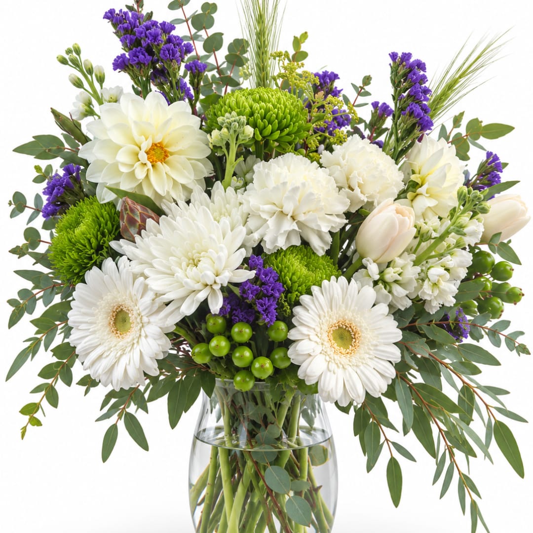 White and green mixed bouquet in a clear glass vase with purple accents