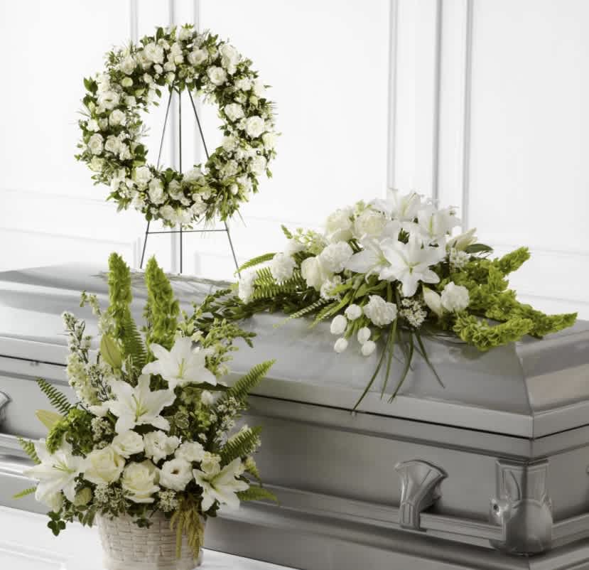 White floral funeral casket spray, wreath, and basket arrangement