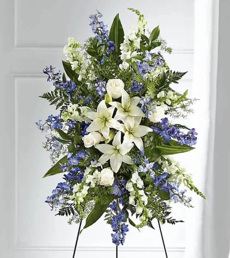 Tall standing floral spray with white lilies and blue flowers