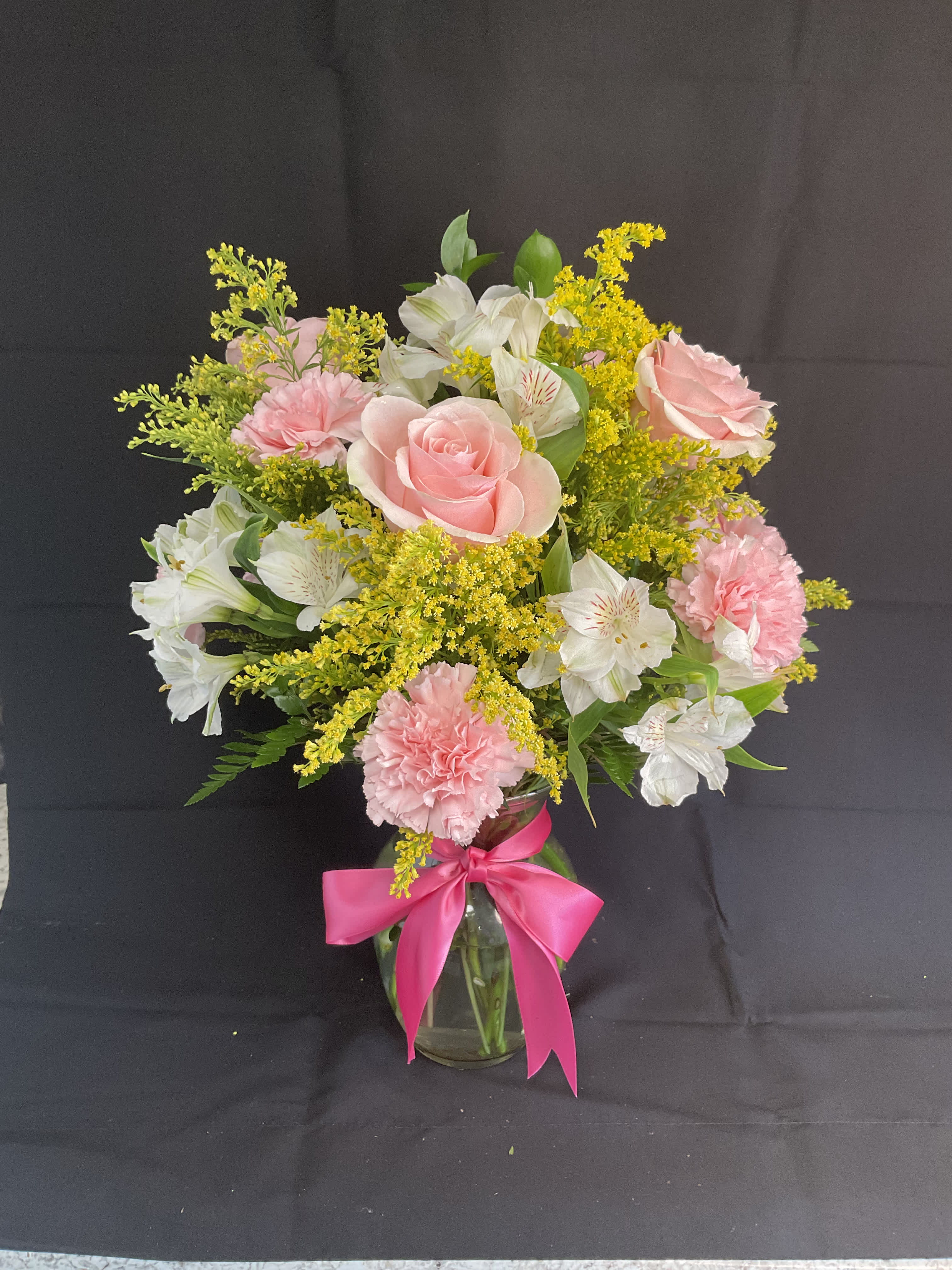 Pink roses and carnations with white alstroemeria in a glass vase
