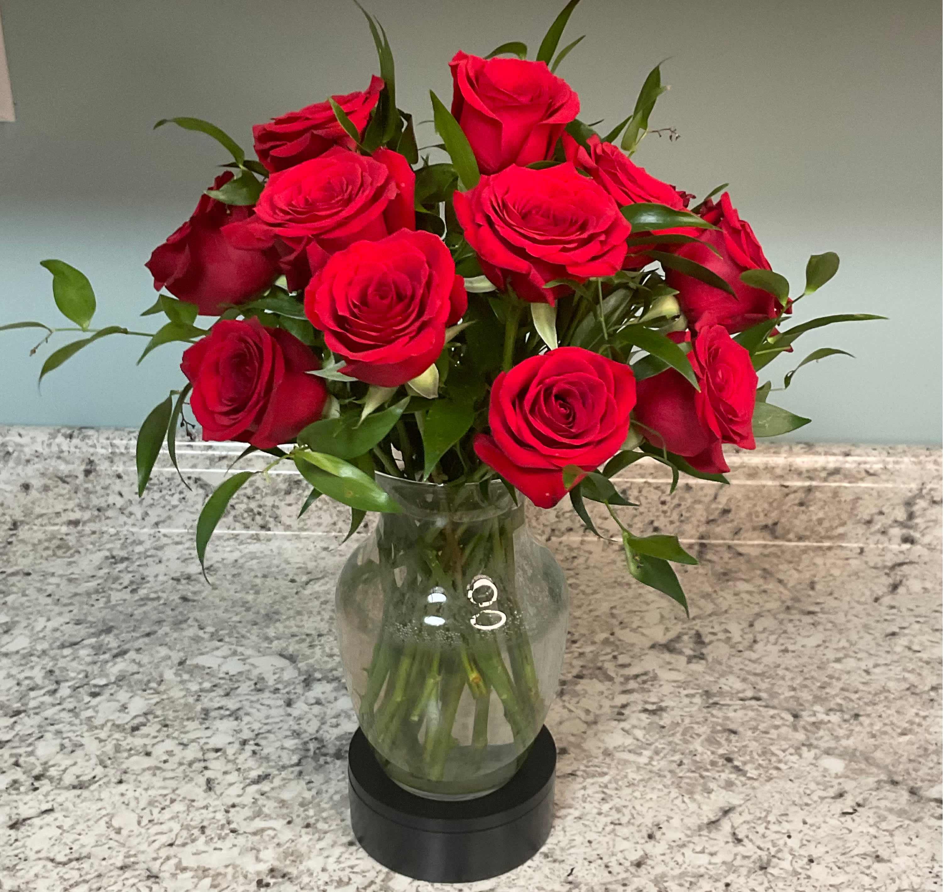 Red roses arranged in a clear glass vase
