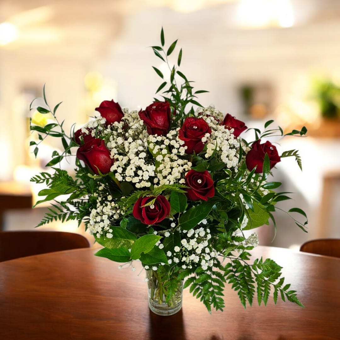 Red roses and white baby's breath in a clear glass vase