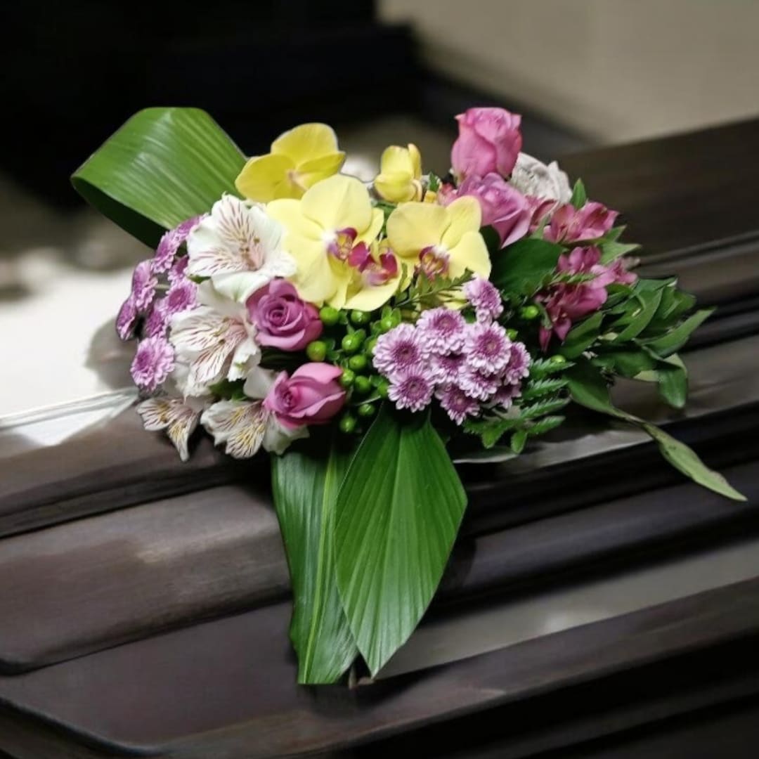 Pink and yellow floral arrangement with orchids and roses