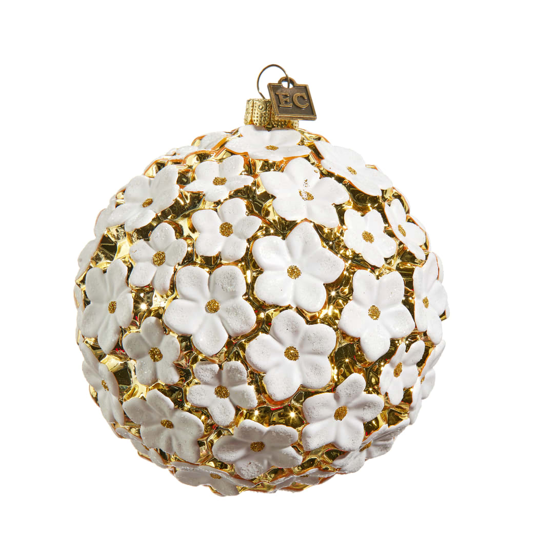 White flower-covered gold ornament with a hanging loop