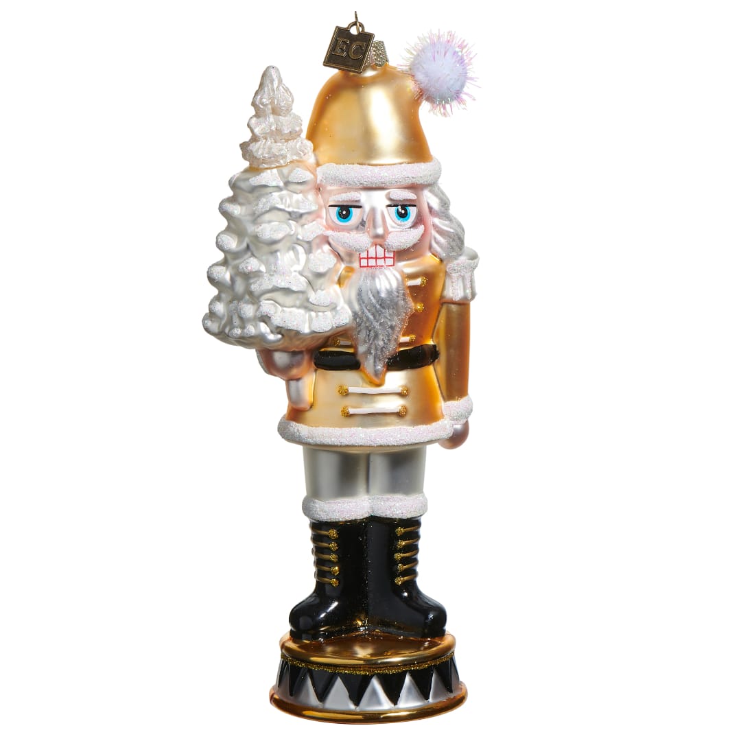 Nutcracker figurine holding a white tree on a plain background