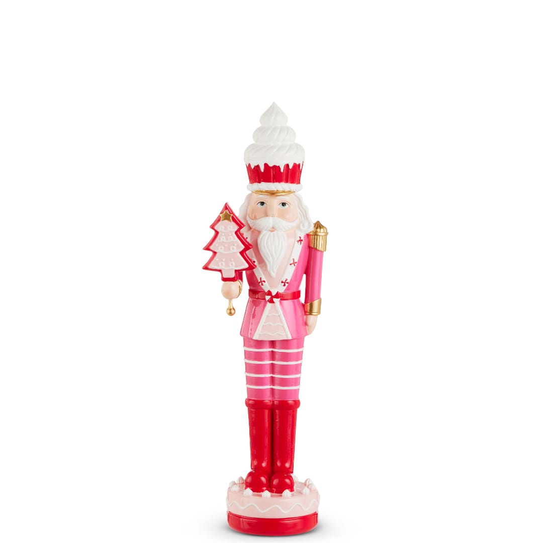 Pink and red nutcracker figurine holding a Christmas tree