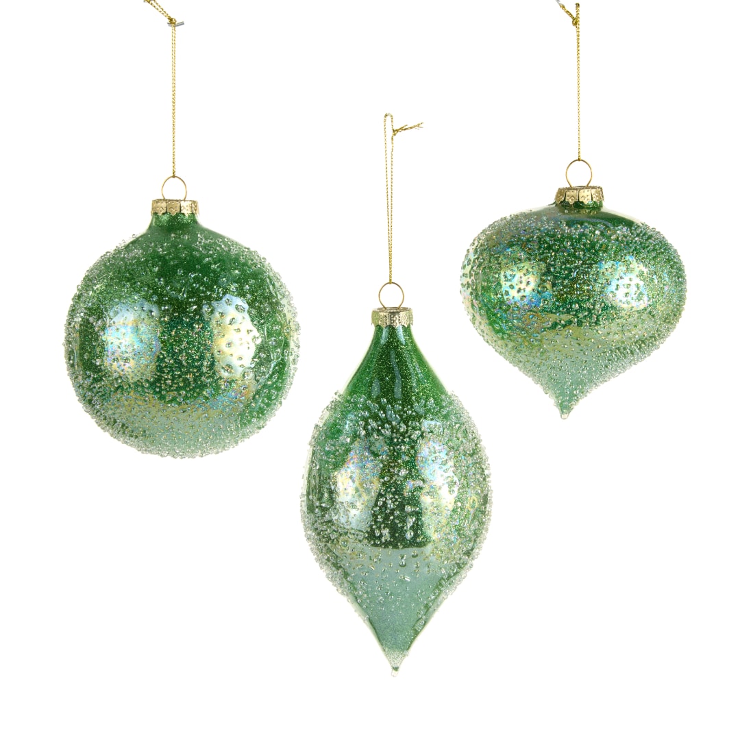 Three green glittered Christmas ornaments hanging on white