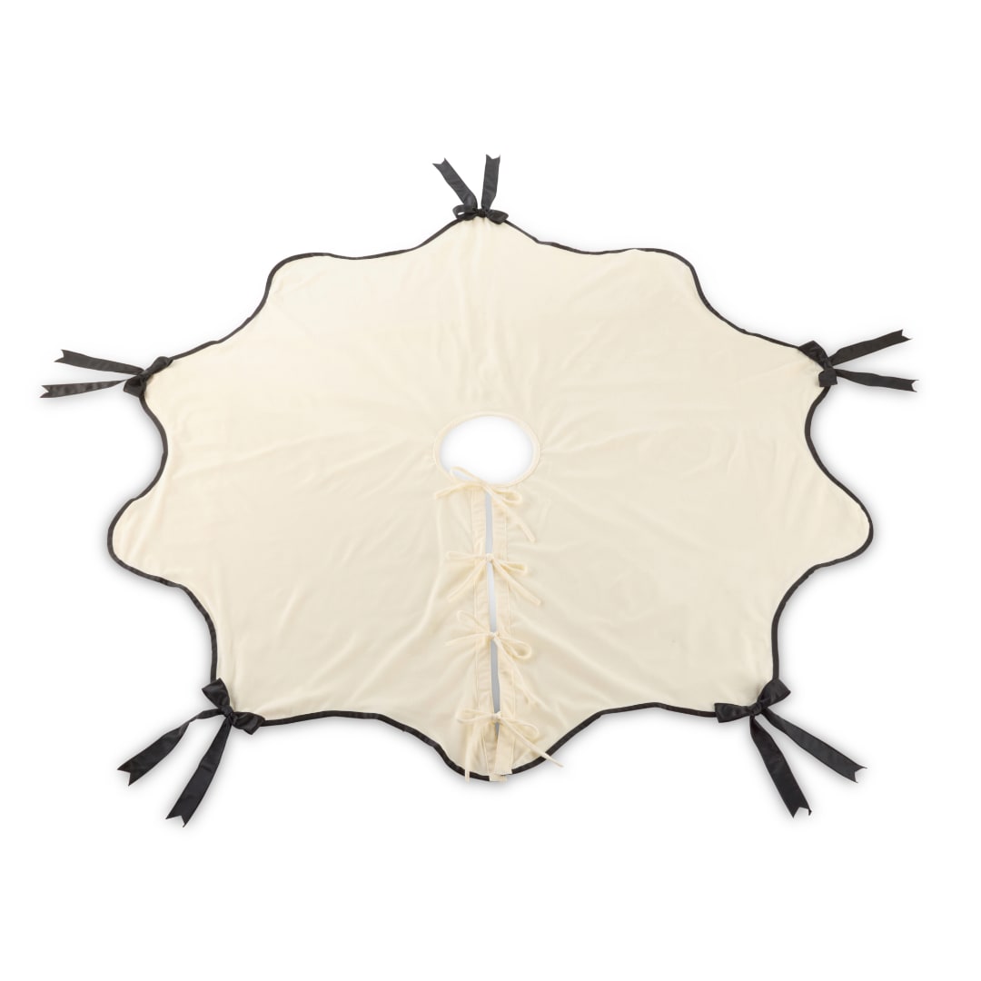 Cream-colored decorative fabric cover with black ribbon ties