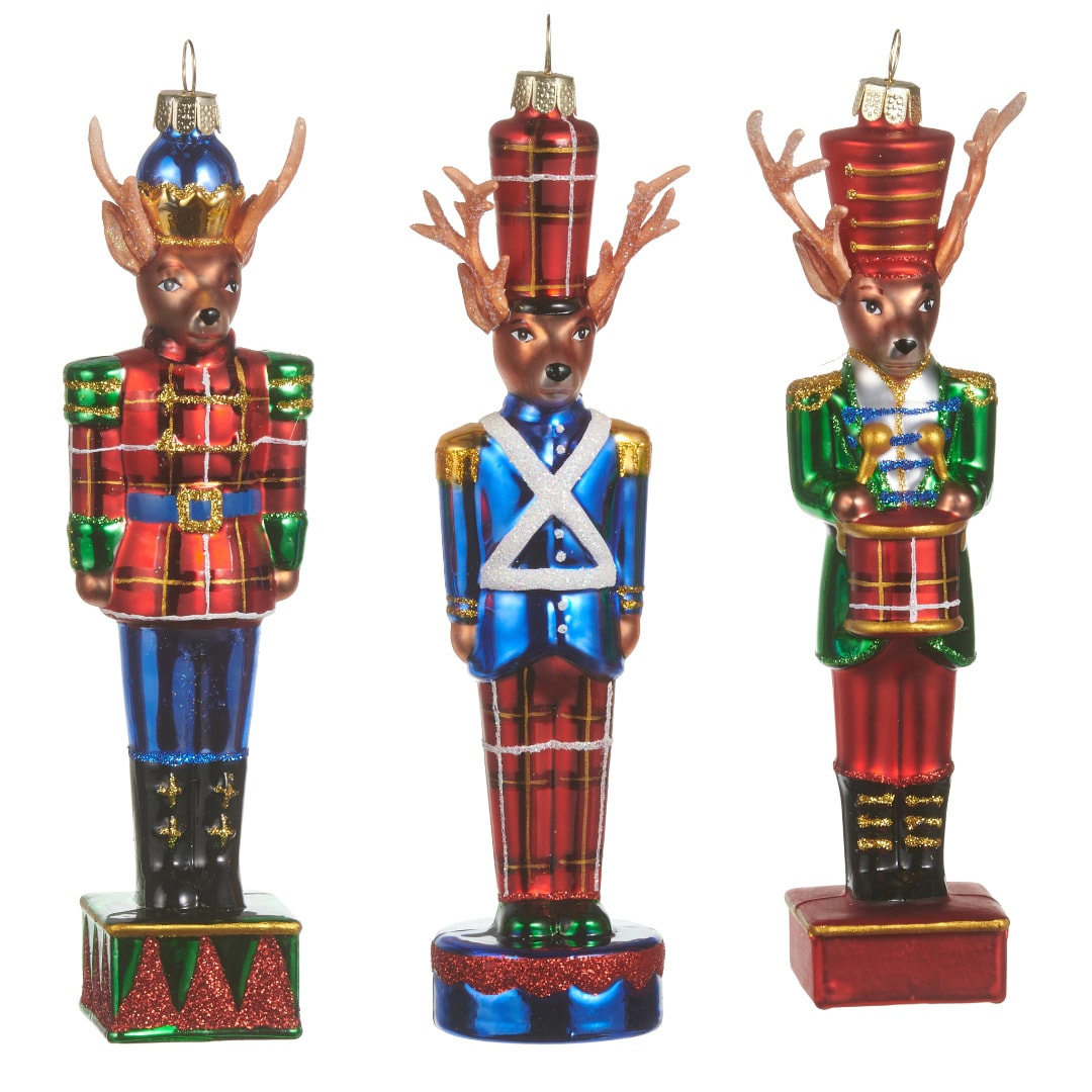 Three colorful nutcracker deer ornaments standing on small bases