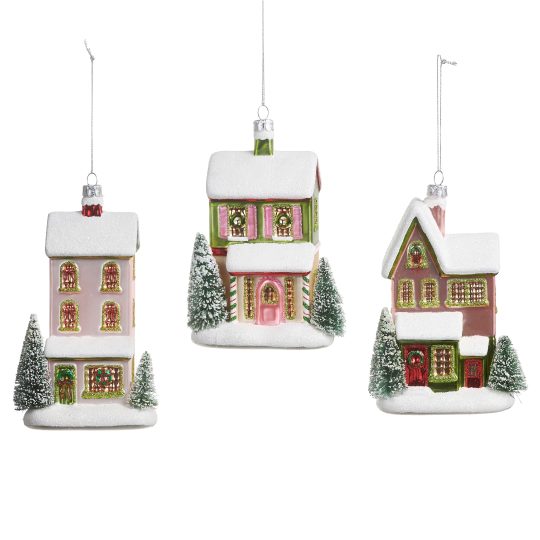 Three snow-covered house ornaments hanging on white strings