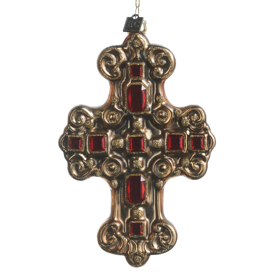Ornate gold cross ornament with red jewel accents on a white background