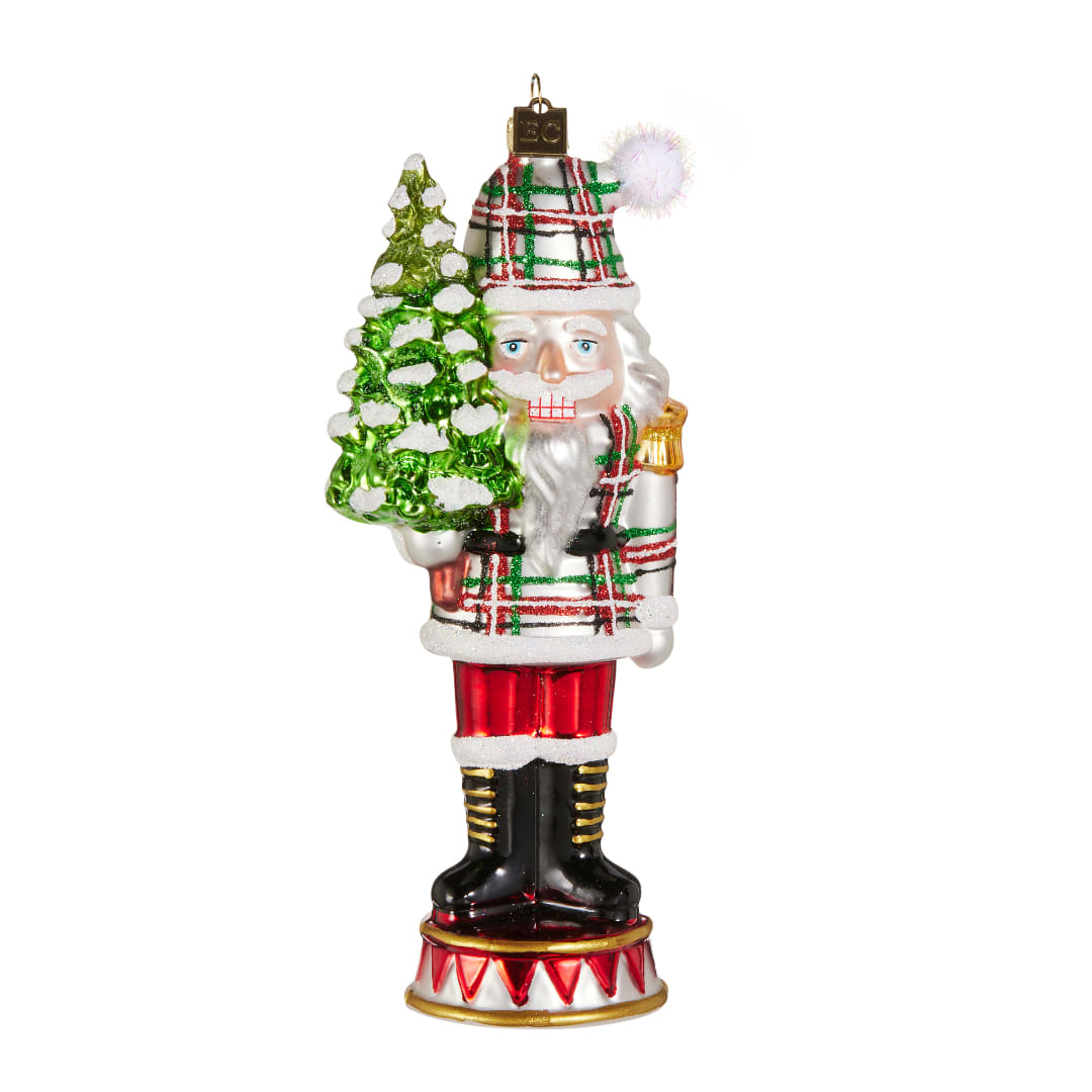 Christmas nutcracker ornament holding a green tree