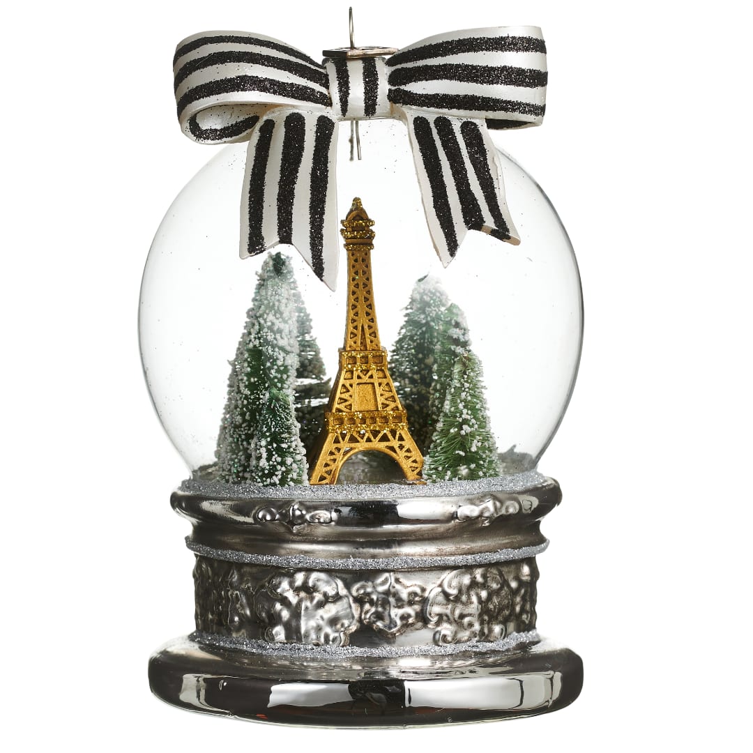 Decorative snow globe with the Eiffel Tower and small trees under a striped bow
