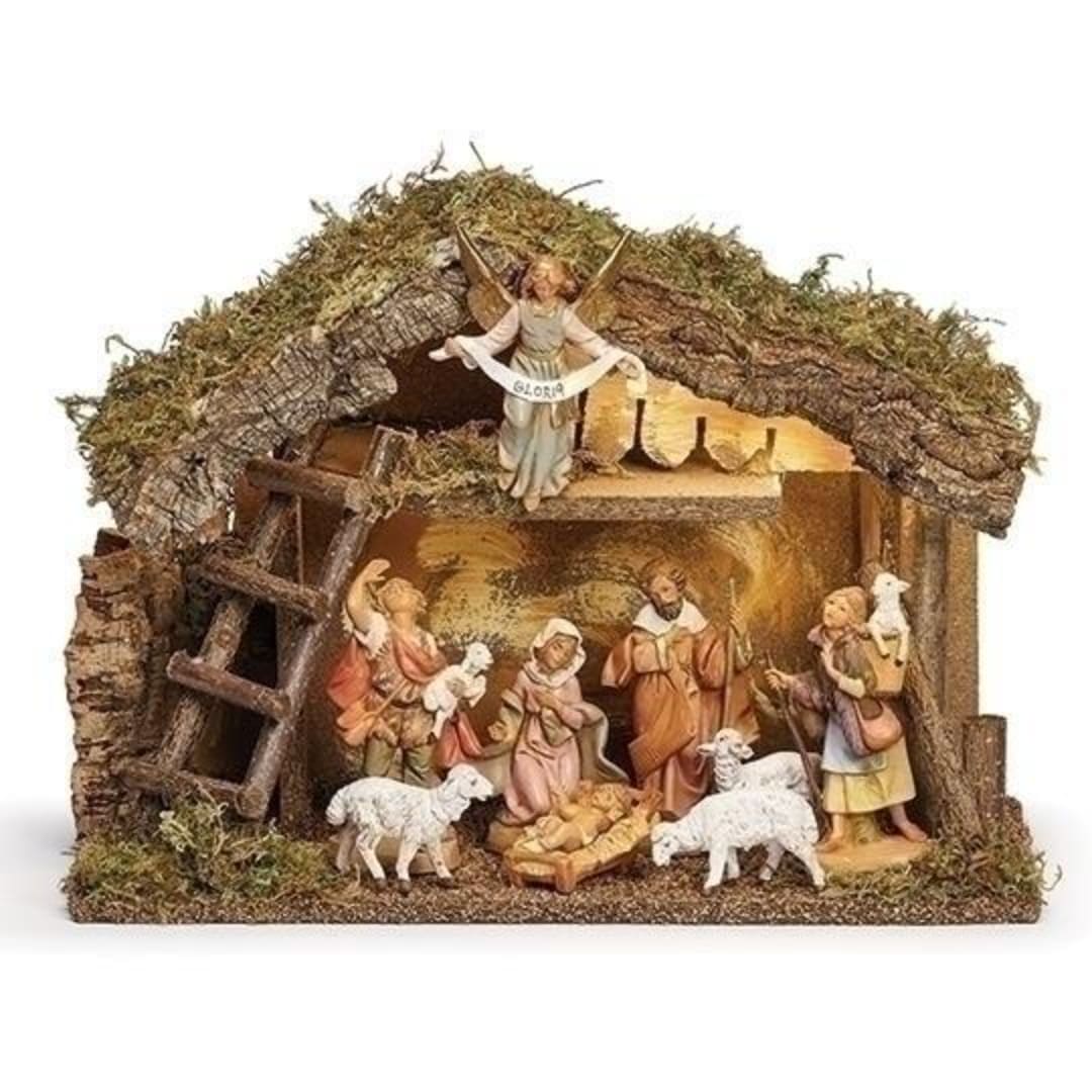 Nativity scene figurines inside a rustic stable with sheep