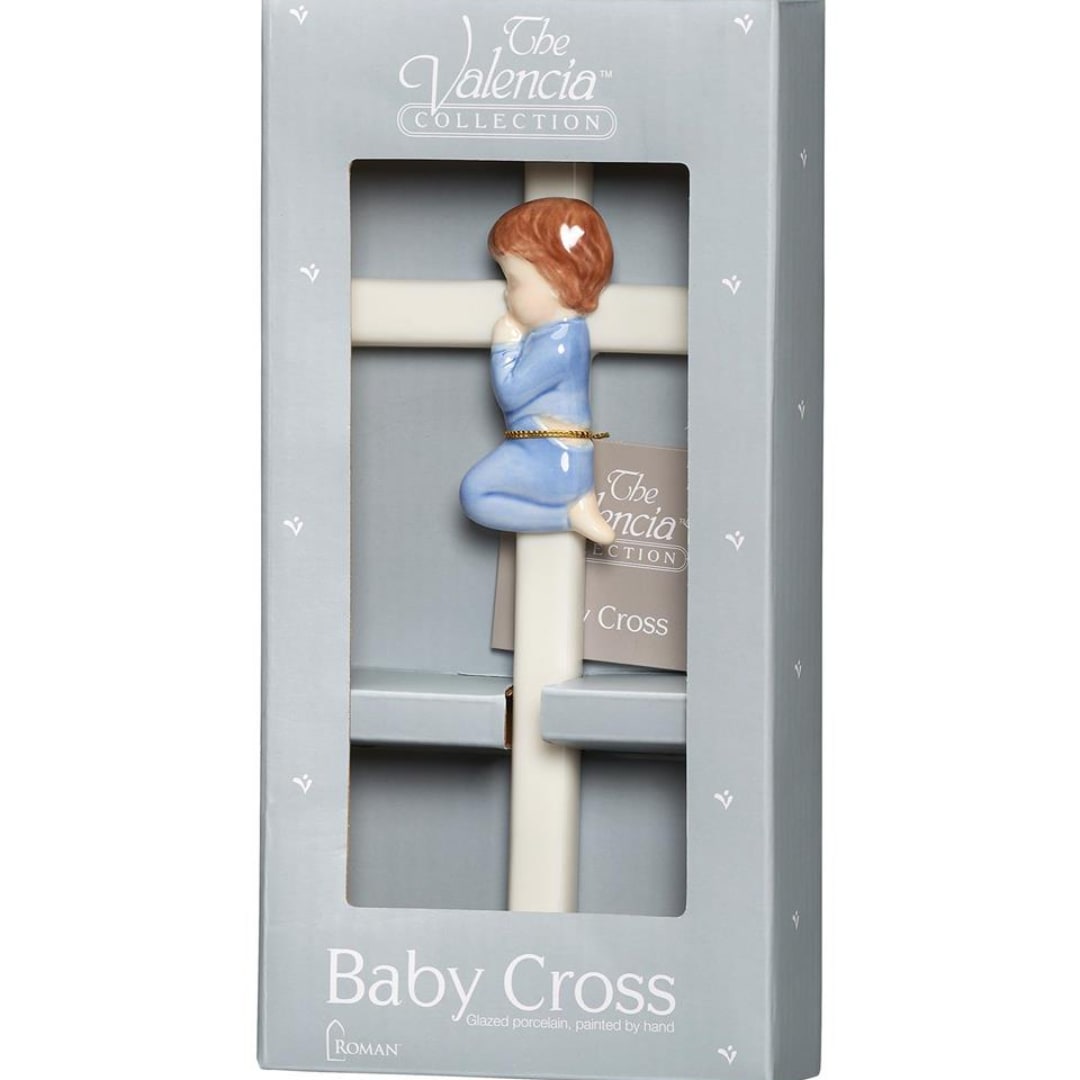 Boxed porcelain baby cross with a small child figure in blue