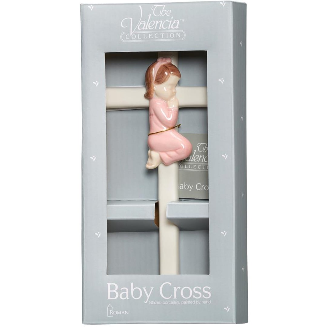 Boxed porcelain baby cross with a pink child figure on the front