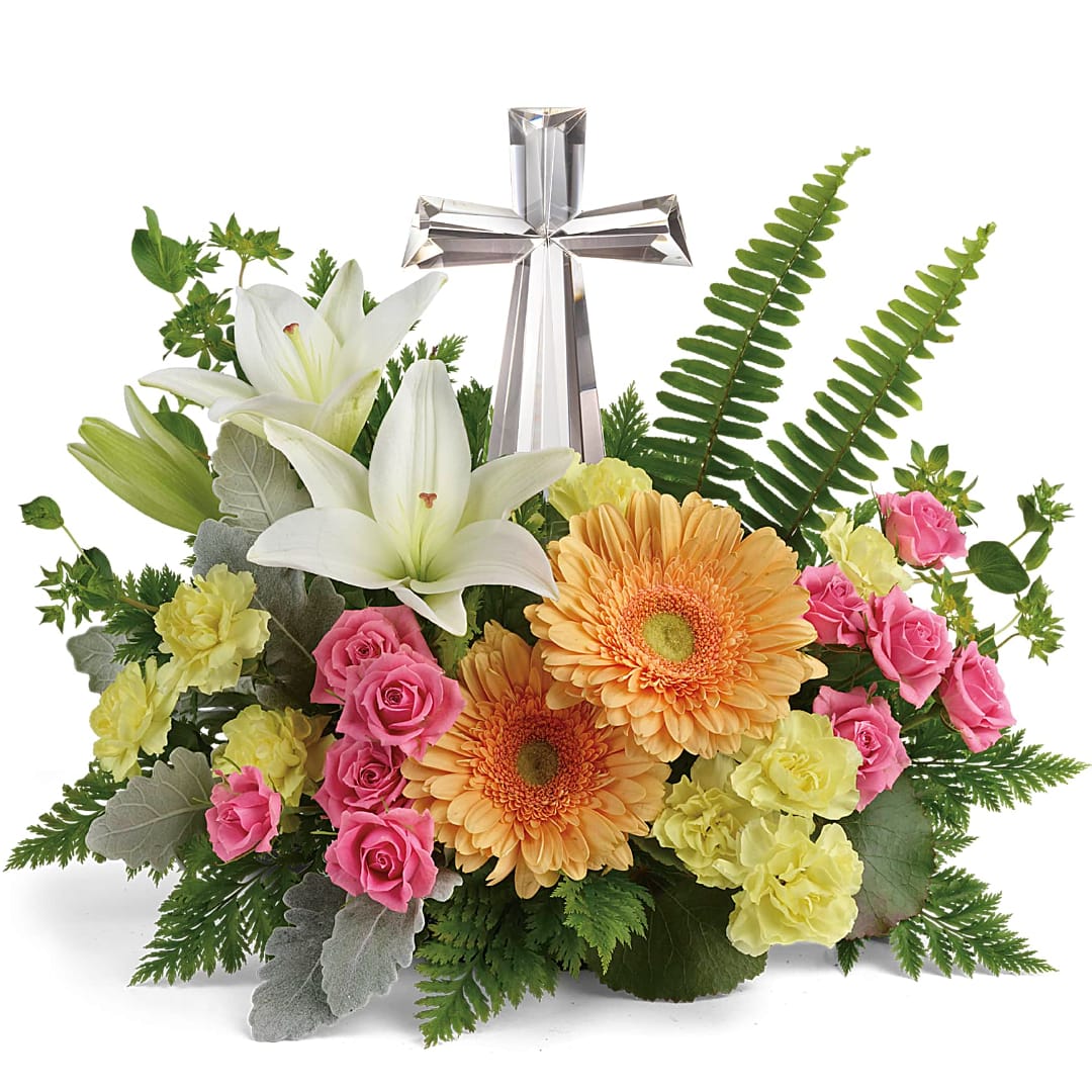 Floral arrangement with white lilies, pink roses, and orange gerbera daisies around a silver cross