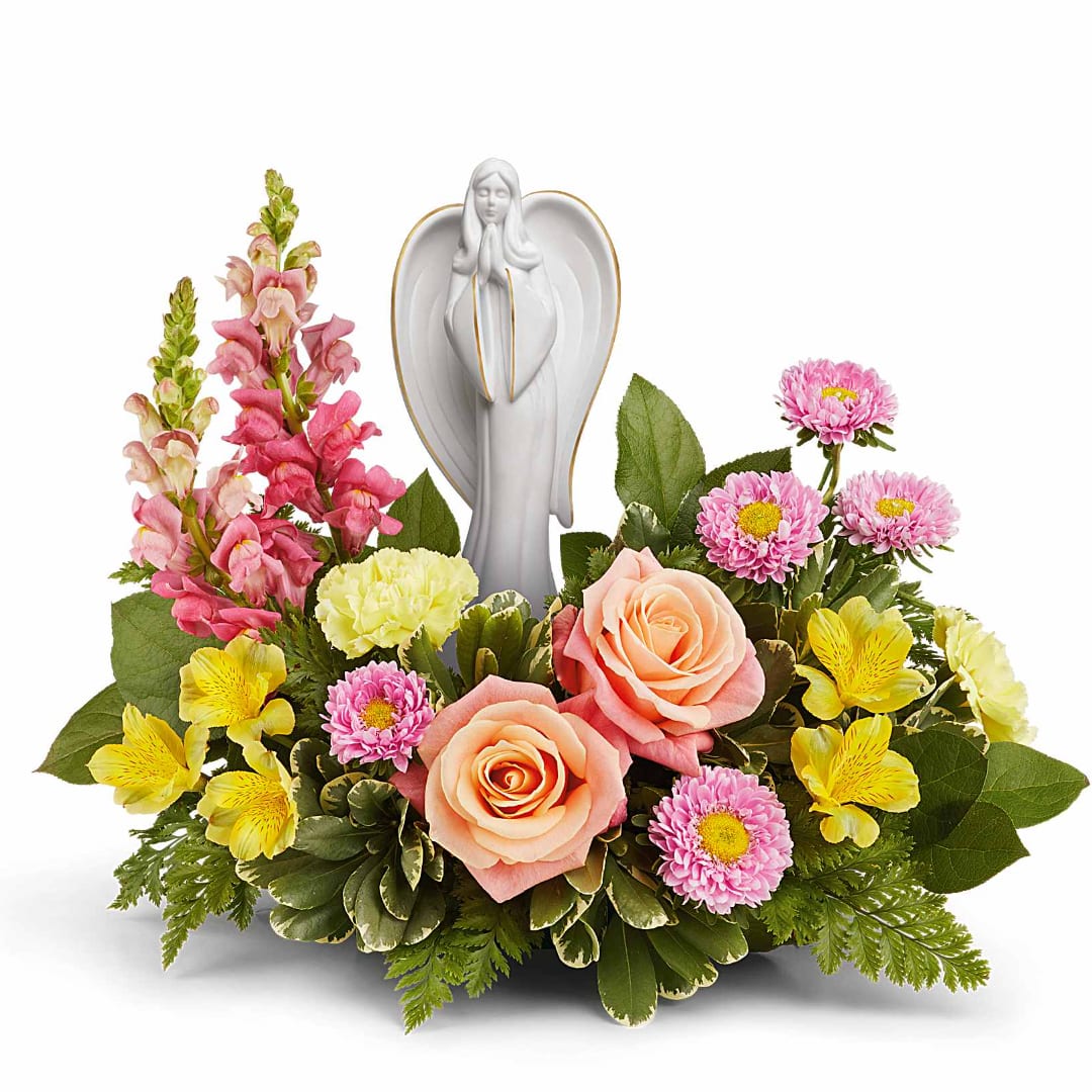 Floral arrangement with roses, daisies, and a praying angel figurine