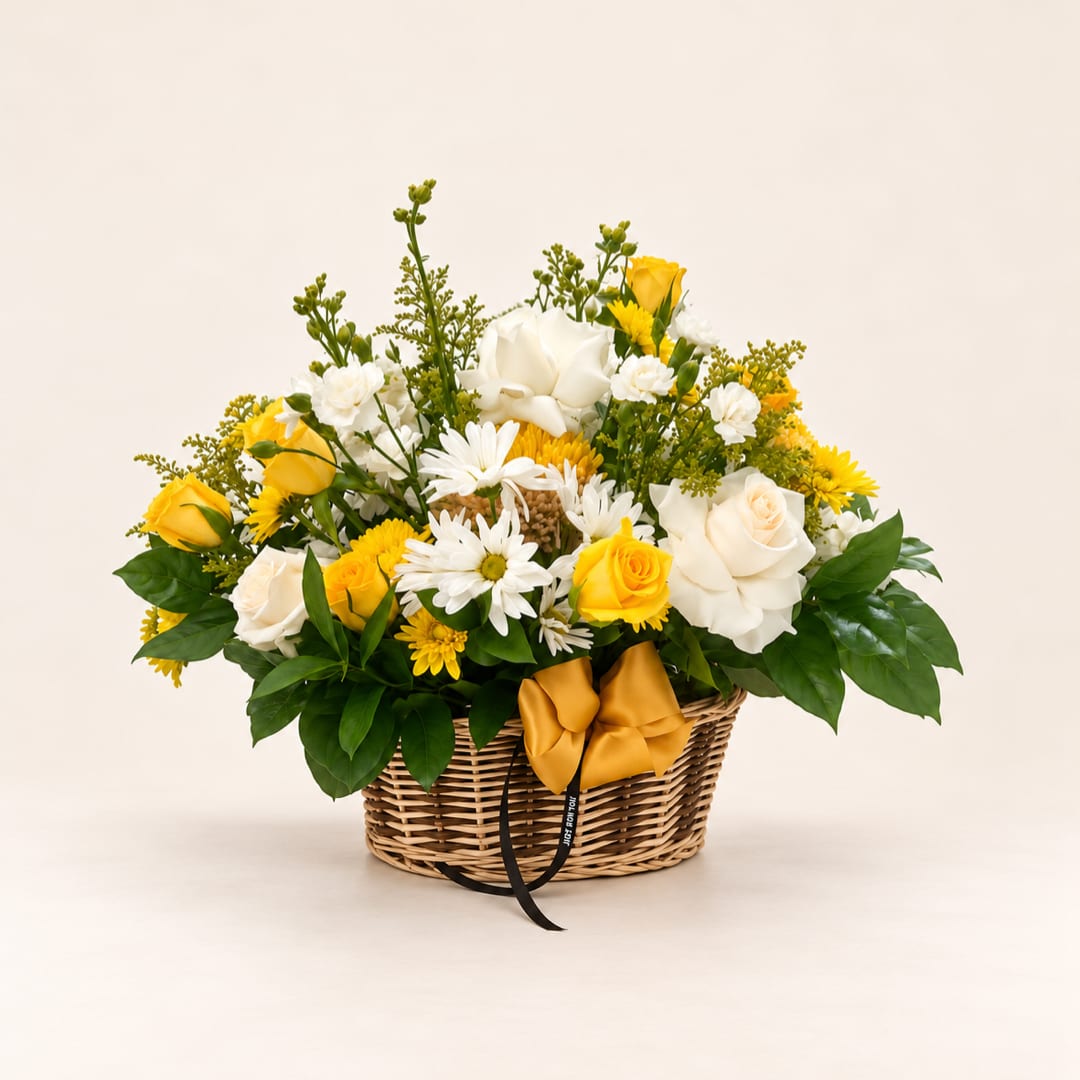 Yellow and white rose bouquet in a wicker basket with a ribbon bow