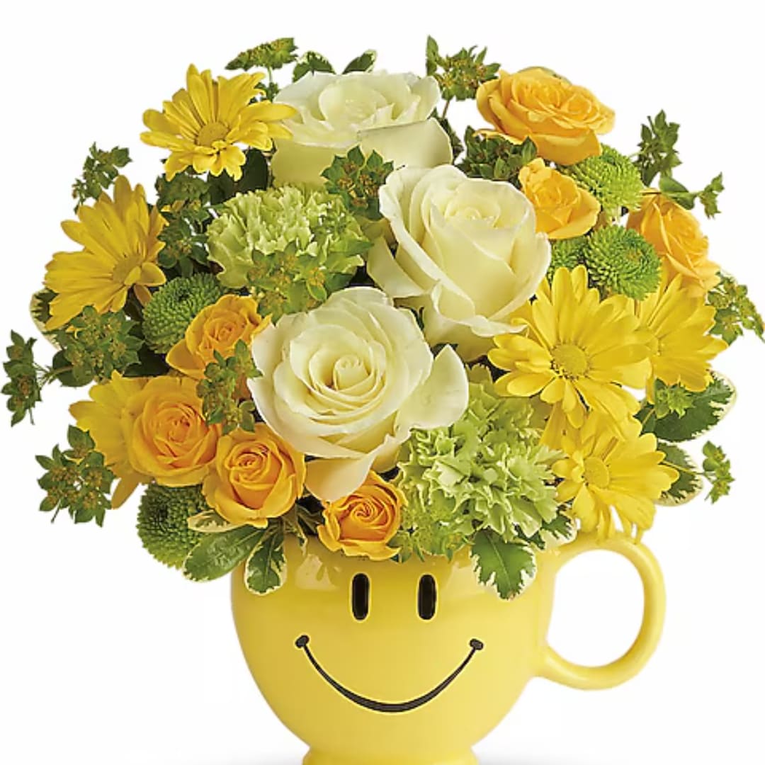 Yellow and white flower arrangement in a smiley-face mug